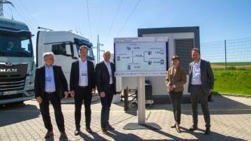 Projektpartner des Forschungsprojekts Spirit-E in Regensburg vor E-Lkw von MAN und Stromspeicher