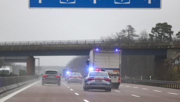 Ein Geldtransporter fährt im Konvoi mit drei Polizeifahrzeugen als Geleitschutz über die Autobahn A9 bei Dessau.