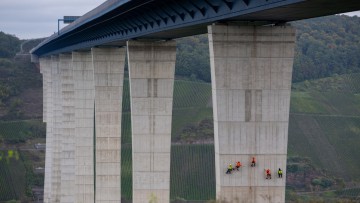 Industriekletterer haben sich an einem Brückenpfeiler der Hochmoselbrücke bei Zeltingen-Rachtig abgeseilt um Risse im Beton zu finden und zu dokumentieren.