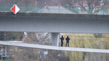 Mitarbeiter des Landesamt für Straßenbau und Verkehr sind bei einer Bauwerksdiagnostik unterhalb der gesperrten Elbbrücke in Bad Schandau mit Seilen gesichert