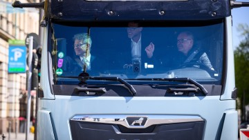 Bundesverkehrsminister Patrick Schnieder (l, CDU), macht am 23. April 2026 zusammen mit Wolfgang Brand, CFO von Milence, dem Betreiber des größten öffentlichen Schnellladenetzes für schwere Nutzfahrzeuge in Europa, und dem Fahrer Michael Noll (r) von MAN 