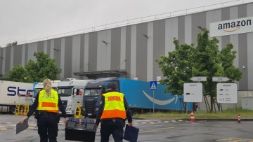 Zollbeamte gehen auf das Gelände eines Logistikunternehmens