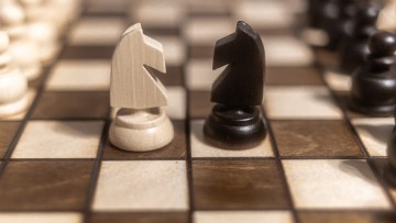 Zwei gegnerische Schachfiguren auf einem Schachbrett
