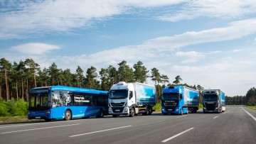 Ein Stadtbus und drei Iveco-Lkw fahren nebeneinander auf einer Testtrecke. Die Fahrzeuge gehören zur Prototypenflotte von ZF