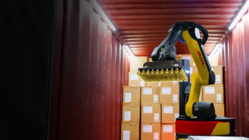 Ein DHL Roboter von Boston Dynamics in einem Container vor Paketen