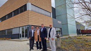 Führungsteam von Crown steht vor Werk 2 in Roding