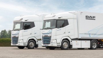 Der neue DAF XG und XG+ Electric parken nebeneinander, die beiden Lkw sind in weiß lackiert und ziehen jeweils einen Kofferauflieger