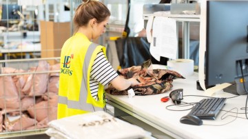 Mitarbeiterin in einem Logistikzentrum bearbeitet Retoure
