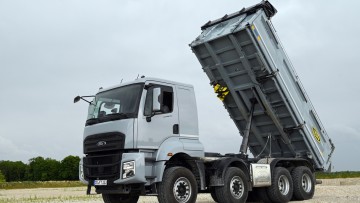 Der Ford F-Line steht mit aufgestellter Kippbrücke auf einer Sandfläche