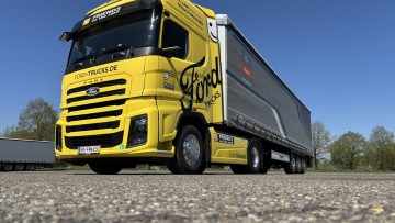Seitliche Frontansicht des neuen Ford F-Max. Die Sattelzugmaschine ist gelb lackiert und zieht einen grauen Auflieger 