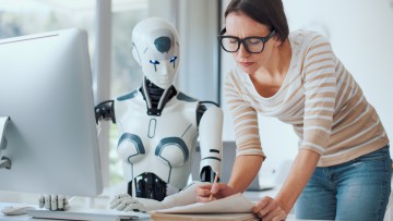 Frau und KI-Roboter arbeiten zusammen in einem Büro