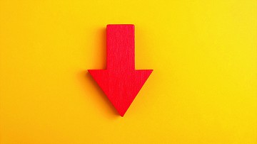 Roter Pfeil zeigt auf gelbem Hintergrund nach unten
