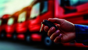 Hand hält Schlüssel vor Lkw