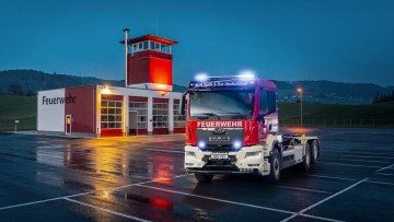 MAN-Feuerwehrfahrzeug vor dem Feuerwehrgebäude bei Nacht