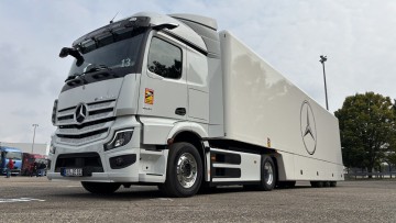Ein Mercedes-Benz eActros 400 fährt als 6x2-Chassis mit Kofferaufbau durch die Landschaft