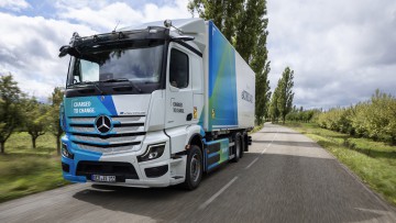 Ein Mercedes-Benz eActros 400 fährt als 6x2-Chassis mit Kofferaufbau durch die Landschaft