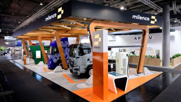 Stand von Milence auf der IAA Transportation 2024: Mehre Lkw stehen an Ladesäulen auf dem Stand