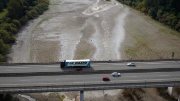 Lkw fährt über eine Brücke über den von Niedrigwasser betroffenen Rhein bei Bendorf