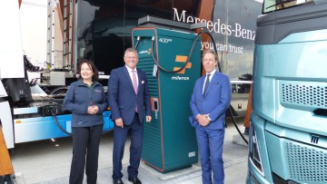 Anja van Niersen, CEO Milence, CEO des Hafens Antwerpen-Brügge, Jacques Vandermeiren, und der Vize-Präsident der Europäischen Kommission, Maros Sefcovic posen mit einer Milence Lkw-Ladesäule