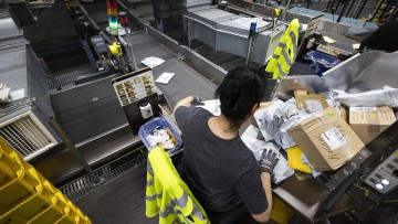 Eine Mitarbeiterin sortiert Postendungen im IPZ. Im Internationalen Postzentrum am Frankfurter Flughafen hat mitten im November die heißeste Jahreszeit begonnen. Der Black Friday steht vor der Tür