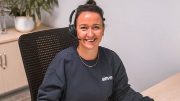 Alice Helbig im grauen Pullover lächelt in die Kamera