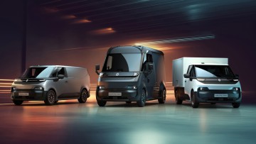 Außenansicht der neuen Renault Elektrotransportern Trafic E-Tech, Goelette E-Tech und Estafette E-Tech vor einem dramatisch ausgeleuchteten Hintergrund