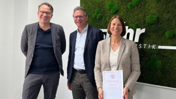 Torsten Denkmann Vorstandsvorsitzender der Agentur für Arbeit (links) Erwin Stöhr Geschäftsführer der Stöhr Logistik GmbH (mitte) und  Stephanie Stöhr Prokuristin (rechts) lächeln mit Auszeichnung in die Kamera