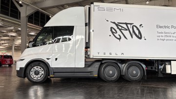 Der Tesla Semi in der Profilansicht. Die weiß lackierte Sattelzugmaschine zieht einen ebenfalls weißen Kofferauflieger