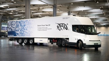 Der Tesla Semi fährt durch eine Messehalle im Rahmen der IAA Transportation 2026. Die weiße Dreichszugmaschine zieht einen ebenfalls weiß lackierten Kofferauflieger