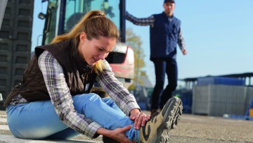 Frau hält sich den Knöchel nach einem Sturz