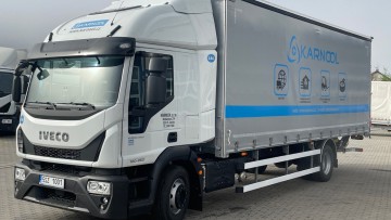 Ein Lkw des tschechischen Unternehmens Karnool parkt auf einem Firmengelände, weitere Lkw und Anhänger sind im Hintergrund zu erkennen