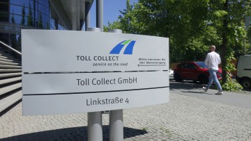 Linkstrasse, Berlin: Ein Schild mit dem Firmenlogo steht vor der Zentrale von Toll Collect.