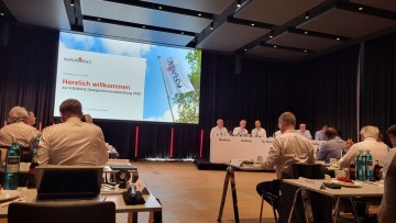 Auf der Delegiertenversammlung des Versicherers Kravag: Delegierte und Gäste der Kravag sitzen im Konferenzsaal des Altantic-Hotels in Heidelberg, vorne sitzen hinter einem Tisch mit den Namen der Notar und die Kravag-Verantwortlichen, darunter Vorstandsc
