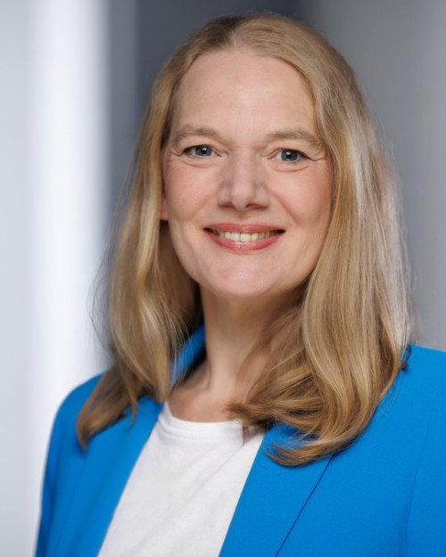 Anja Knoblich in einem blauen Blazer lächelt in die Kamera