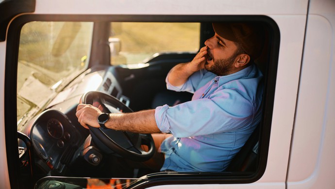 Gähnender mann am Lkw-Steuer