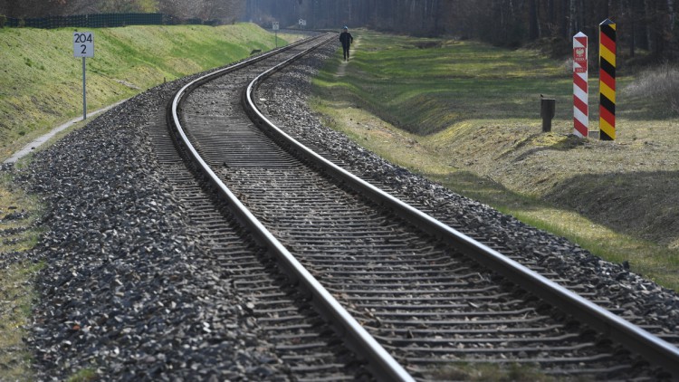 Ein Mensch geht neben der Bahnstrecke am Grenzübergang Ahlbeck - Swinemünde.