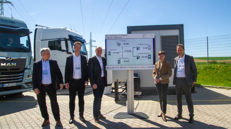 Projektpartner des Forschungsprojekts Spirit-E in Regensburg vor E-Lkw von MAN und Stromspeicher
