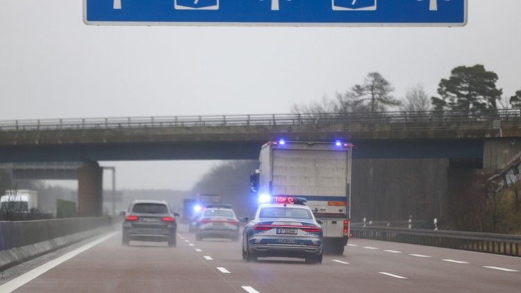 Ein Geldtransporter fährt im Konvoi mit drei Polizeifahrzeugen als Geleitschutz über die Autobahn A9 bei Dessau.