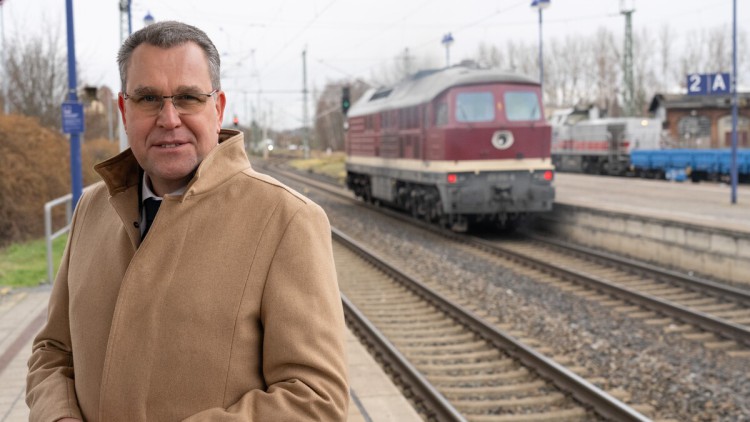 Rainer Genilke (CDU), Brandenburger Minister für Infrastruktur und Landesplanung, steht auf dem Bahnsteig des Bahnhofs Lübbenau vor einer sowjetische Diesellokomotive der Baureihe BR 130.