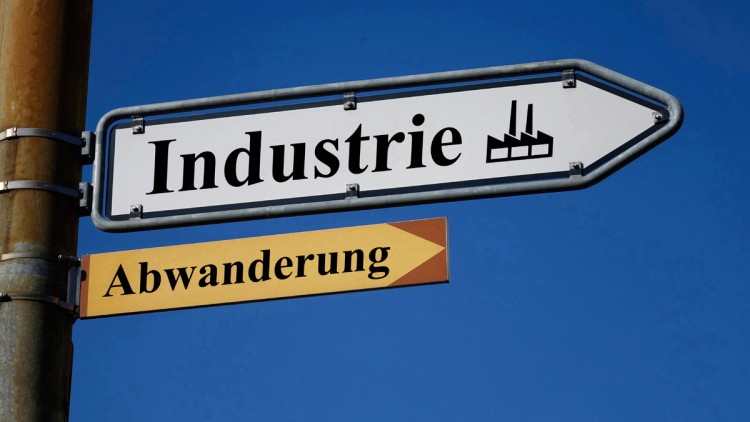 In zwei Wegweisern stehen die Schriftzuege Industrie und Abwanderung.