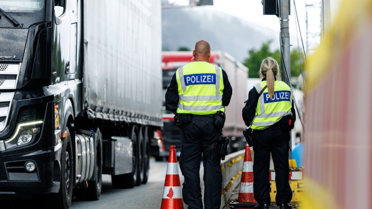 Zwei Polizisten an der Grenzkontrollstelle der Bundespolizei an der A 93 bei Kiefersfelden (Bayern) kontrollieren einen Lkw.