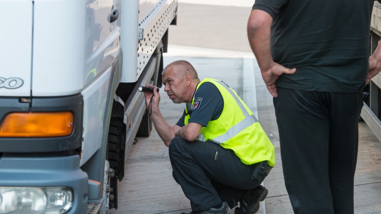 Ein Polizeibeamter überprüft einen Lkw auf einem Rastplatz an der Autobahn