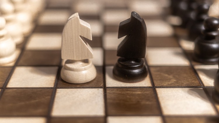 Zwei gegnerische Schachfiguren auf einem Schachbrett