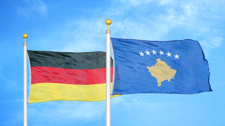 Deutschland-Flagge und Kosovo-Fahne wehen nebeneinander im Wind