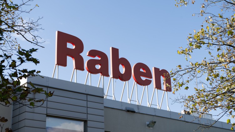 Raben-Schild auf Haus vor blauem Himmel in Deutschland