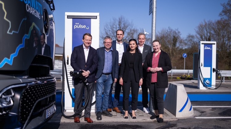 Bei der Eröffnung des Megawatt-Ladeparks für E-Lkw an der Autobahn 7 bei Schwarmstedt,  stehen verschiedene Personen an einer Ladesäule neben einem Lkw, v.l.n.r.: Aral Vorstand Alexander Junge, Björn Gehrs (Bürgermeister der Samtgemeinde Schwarmstedt), Ha