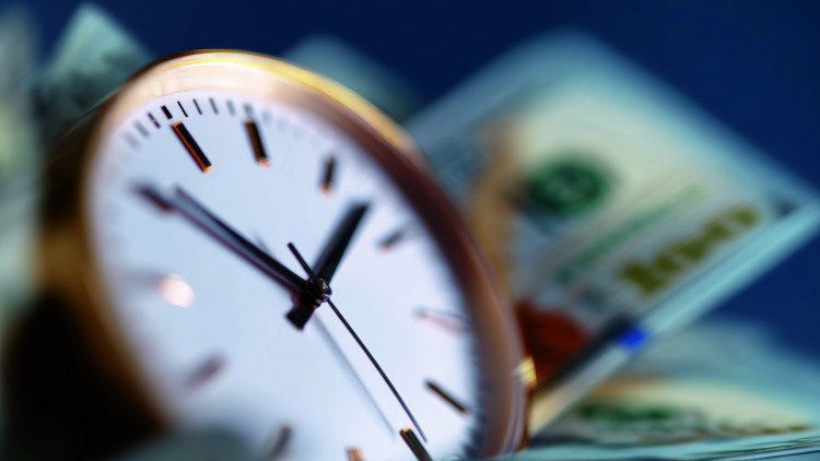 Säumniszuschläge: Wie Speditionen und Logistiker teure Fehler vermeiden können Uhr mit Geldscheinen
