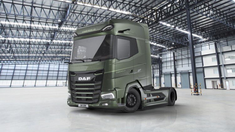 Ansicht des DAF XG+ Emerald Edition von vorn seitlich. Die grün lackierte Sattelzugmaschine parkt in einer Lagerhalle