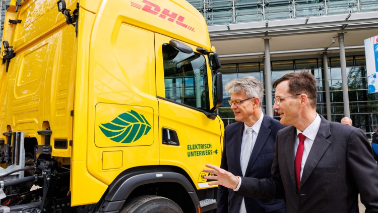DHL-Chef Tobias Meyer zeigt Bundesverkehrsminister Patrick Schnieder den EREV-Lkw von Scania
