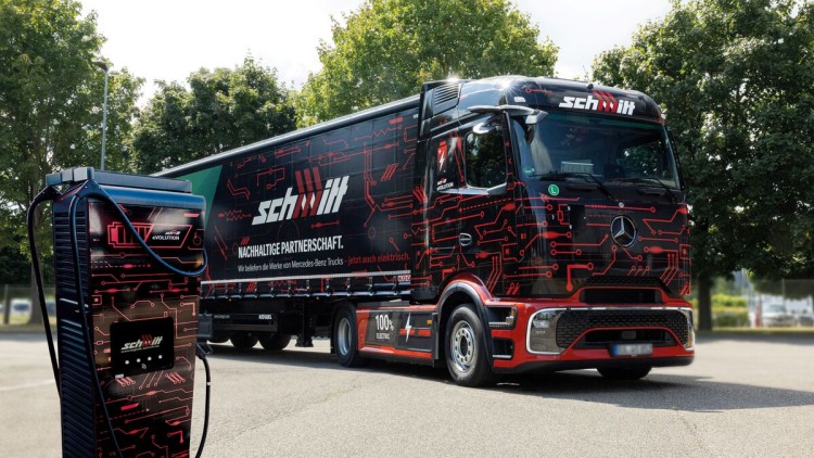 Auf dem Betriebsgelände von Logistik Schmitt steht ein eActros 600 neben einer Ladesäule im Corporate Design des Logistikdienstleisters. Das Unternehmen hat neben den E-Trucks von Daimler auch Fahrzeuge der Hersteller MAN und Volvo im Fuhrpark. Anfang 202